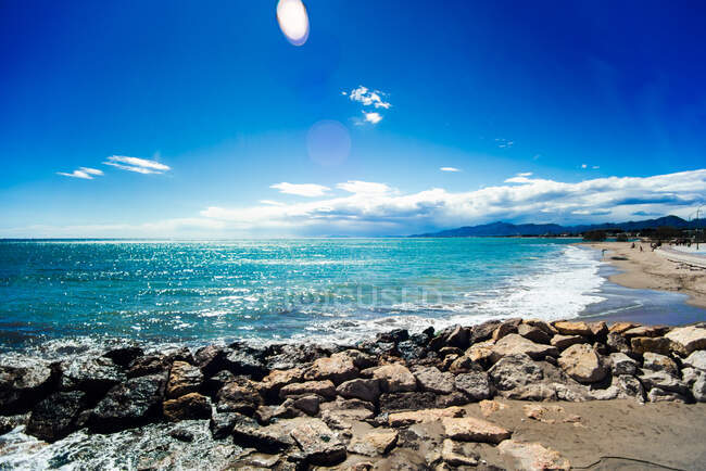 Picturesque view to blue seascape and rocky coast in sunny cloudless day. — Stock Photo