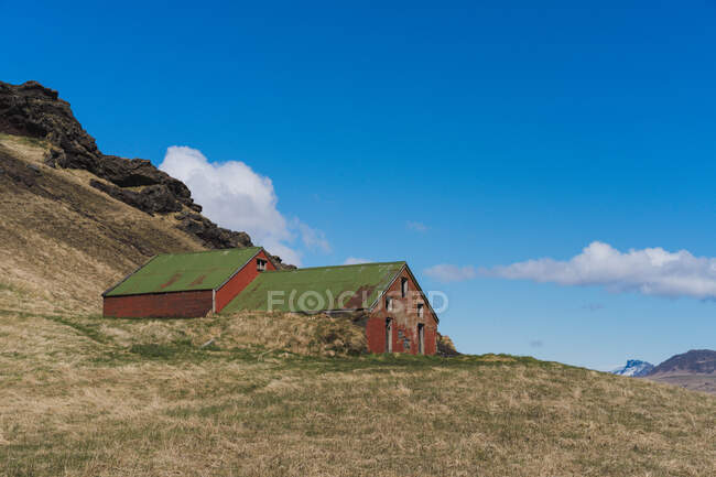Paisagem de pequena casa vermelha no vale a pé de montanhas na Islândia — Fotografia de Stock