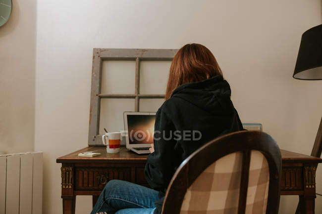 Junge Frau tippt auf Laptop am Oldtimertisch — Stockfoto