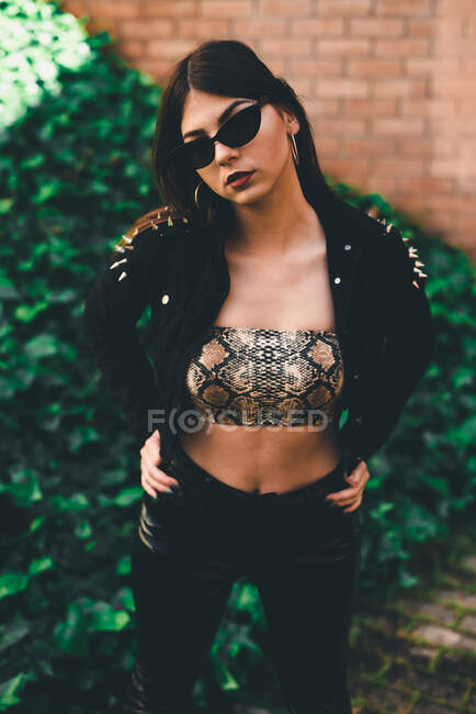Belle brune posant avec des lunettes de soleil noires — Photo de stock