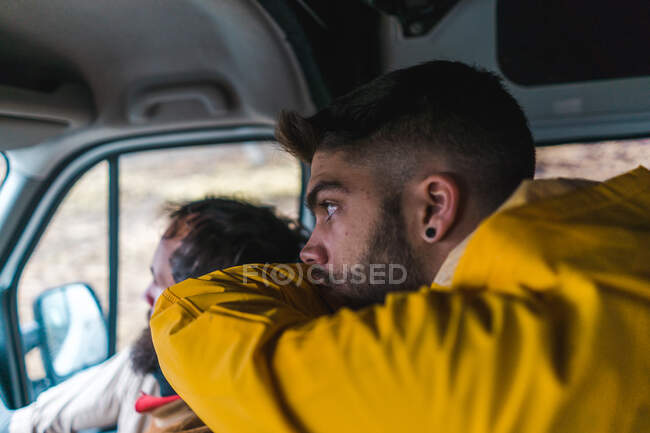 Deux hommes assis dans un joli van et regardant la route tout en voyageant à travers l'Islande ensemble. — Photo de stock