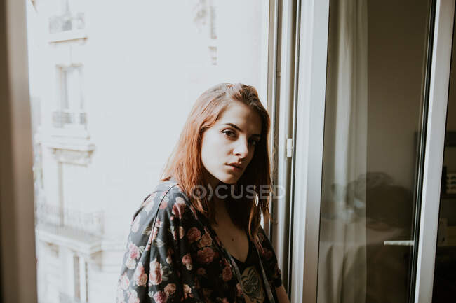 Young woman posing at window — Stock Photo