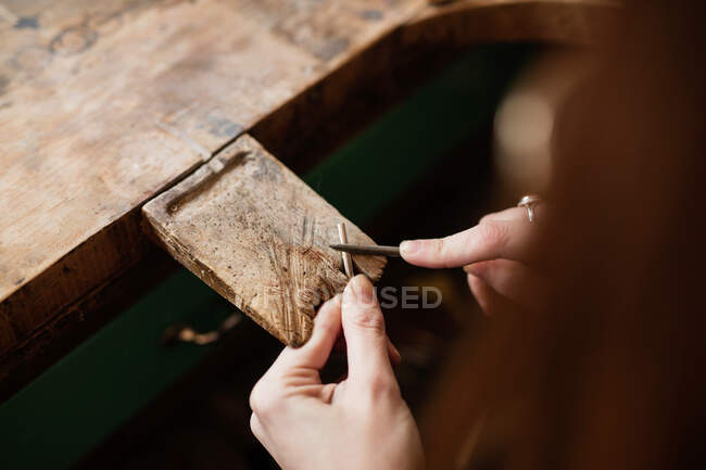 Crop close up hands of person cutting stick with knife on worktop — Stock Photo