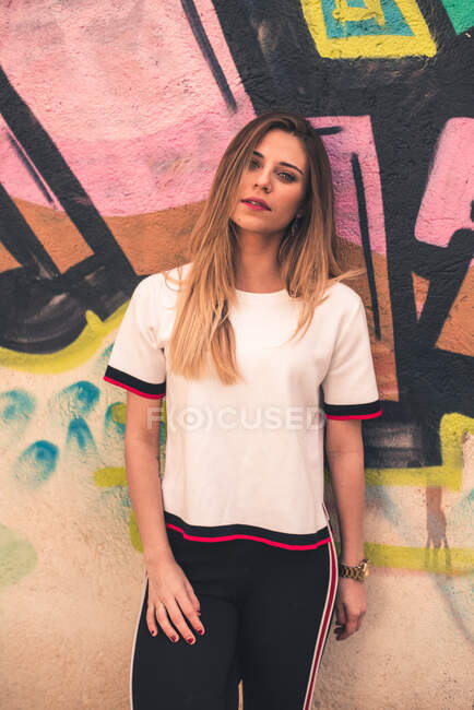 Trendy sportive girl against painted wall — Stock Photo