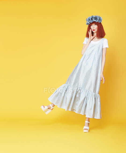 Vista isolada do modelo de cabelos vermelhos em vestido azul no fundo amarelo — Fotografia de Stock