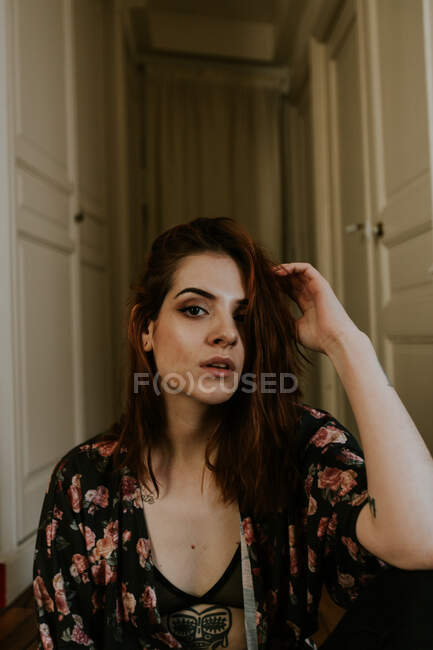 Tattooed woman sitting at home — Stock Photo
