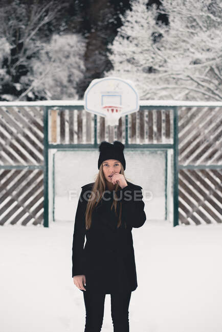 Молода леді залишається в зимовій природі, дивлячись на камеру — стокове фото