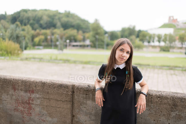 Молода стильна жінка в чорній сукні на відкритому повітрі — стокове фото