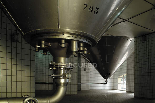 Великі резервуари для зберігання пива з міді розміщені в просторому приміщенні заводу — стокове фото