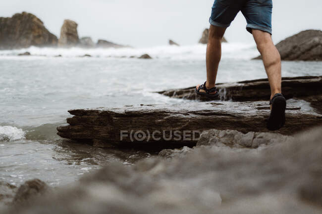 Человек, бегущий по береговой линии от песка до моря в Кантабрии, Испания — стоковое фото
