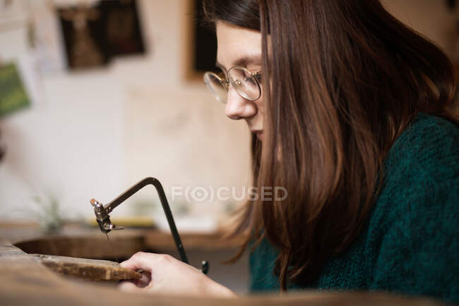 Женщина вырезает украшения из коры — стоковое фото