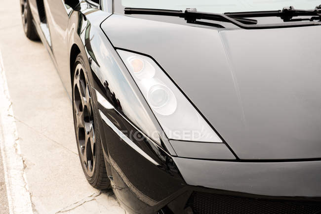 Крупним планом чорний розкішний автомобіль на тротуарі на вулиці — стокове фото