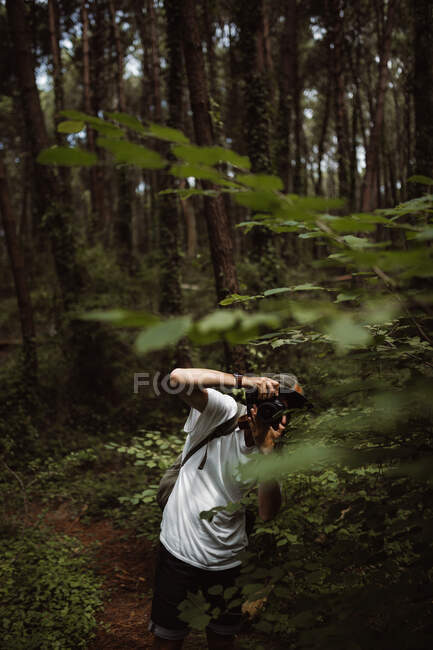 Mann macht Foto von Wald auf Pfad zwischen Bäumen mit Rucksack in Kantabrien, Spanien — Stockfoto