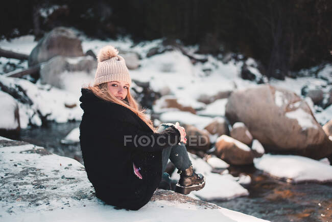Femme souriante à la rivière en hiver — Photo de stock