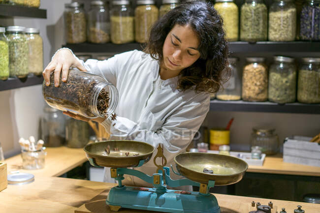 Woman pouring spices on scales — Foto stock