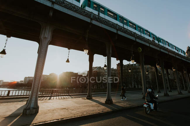 Rückansicht einer unkenntlich gemachten Person, die auf einem Motorroller auf einer Straße in Paris unterwegs ist. — Stockfoto