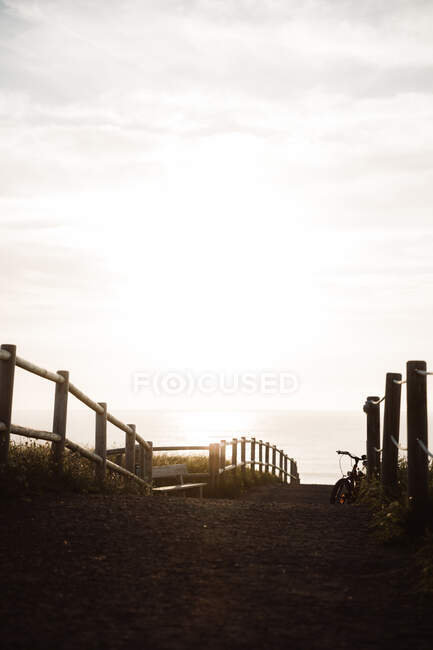 Pasarela con asiento y bicicleta a orillas del mar sobre fondo celeste en Cantabria, España - foto de stock