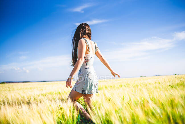 Chica de pie en el campo en un día soleado - foto de stock