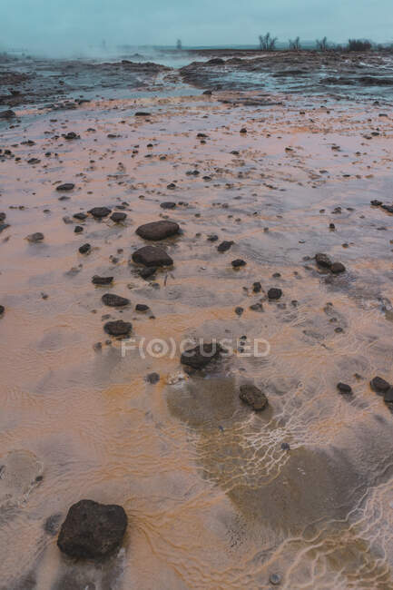 Petits rochers et eau sale sur le chemin de la belle source chaude en Islande. — Photo de stock