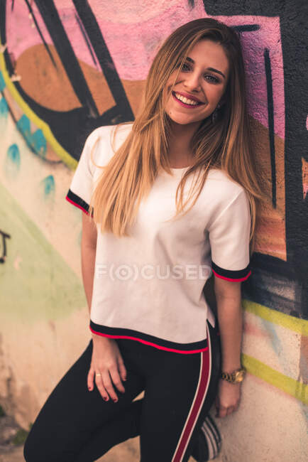 Trendy ragazza sportiva contro parete dipinta — Foto stock