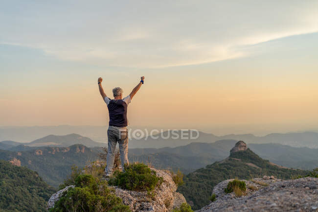 Hombre anónimo disfrutando de la vista desde la montaña - foto de stock