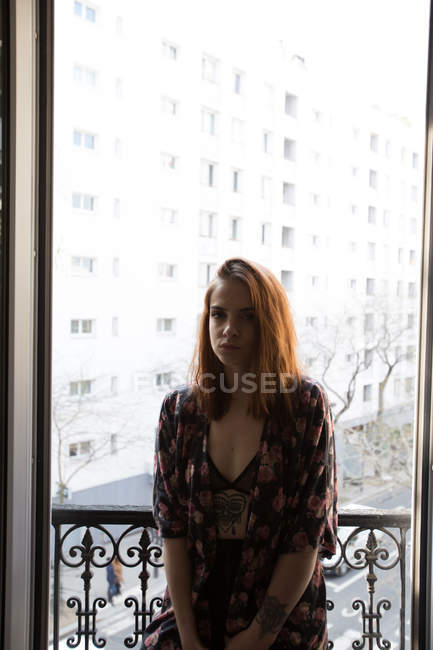 Jovem mulher de pé na janela — Fotografia de Stock