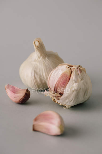 Spicchi d'aglio fresco su sfondo grigio — Foto stock
