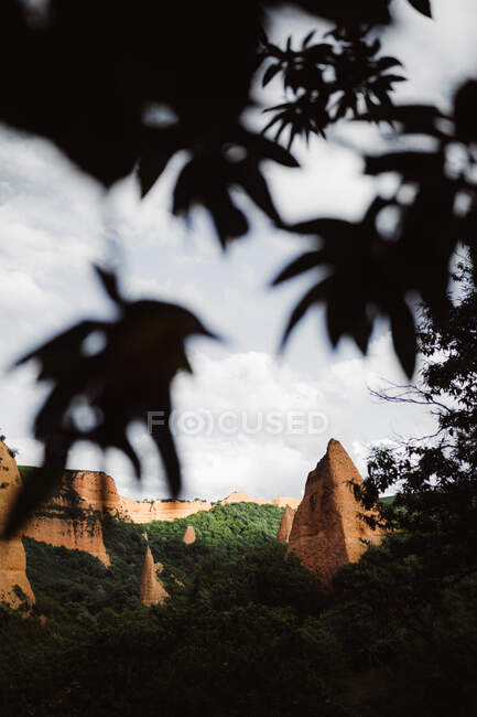 Каменистая гора, стоящая между зеленым лесом на фоне неба в Кантоне, Испания — стоковое фото