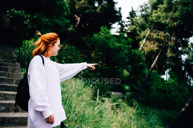 Giovane donna con zaino in corso nella foresta — Foto stock