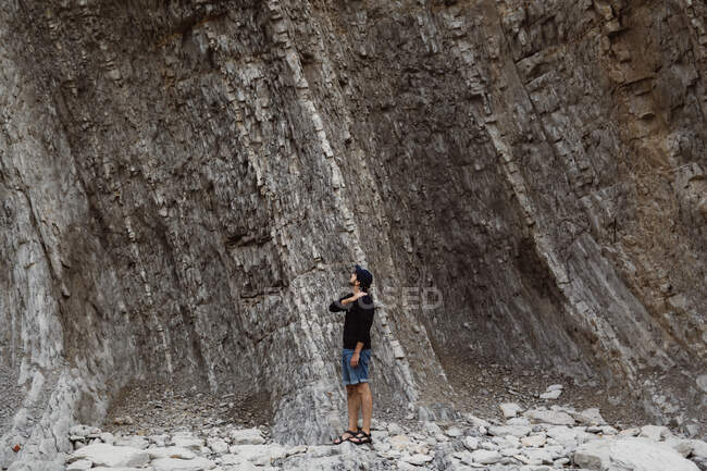 Man looking up to climb on rock — Stock Photo
