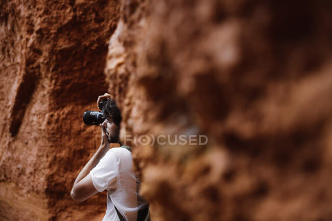 Vista lateral se o homem de colheita com câmera fazendo foto em montanhas rochosas em Cantabria, Espanha — Fotografia de Stock
