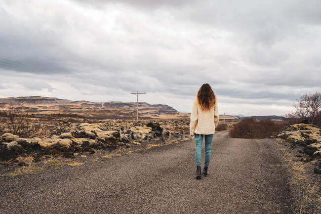 Mujer de pie sobre un fondo pedregoso pintoresco - foto de stock