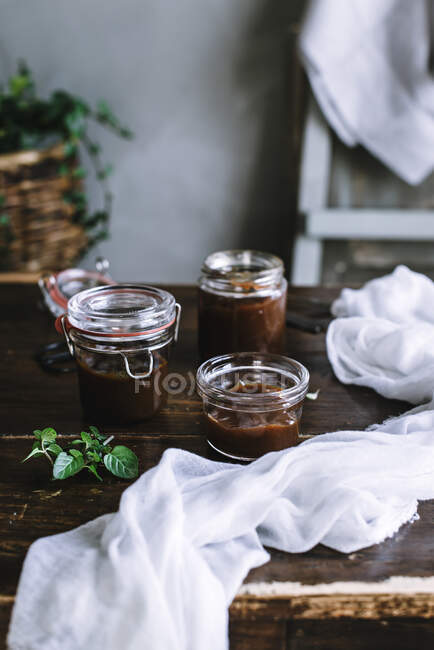 Bowl of caramel sauce near jar — Stock Photo