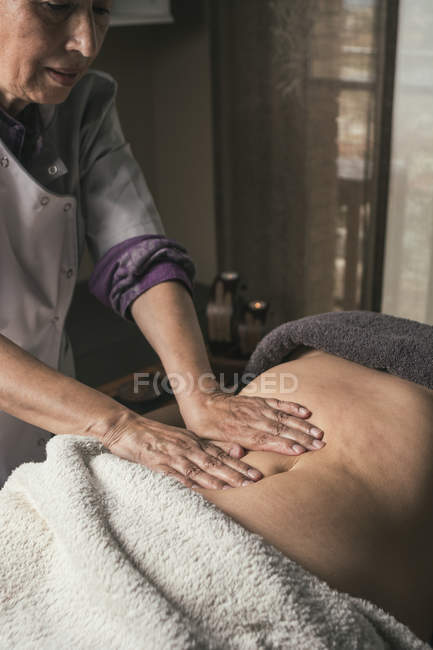 Therapeut tut orientalische Massage für Frau im Massageraum — Stockfoto