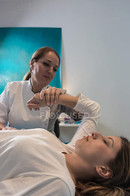 Thérapeute masser la main féminine dans la salle de massage — Photo de stock