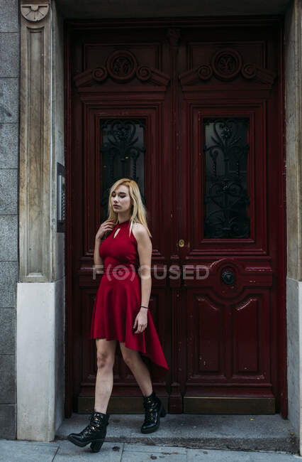 Молодая привлекательная женщина стоит перед старыми воротами — стоковое фото