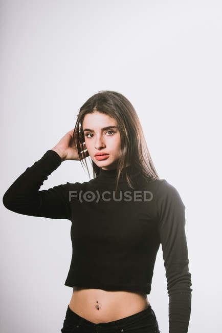 Menina em camisola de pescoço de tartaruga preta posando em fundo cinza — Fotografia de Stock