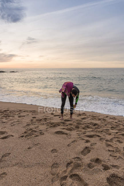 Triatleta caminando en la playa de arena - foto de stock