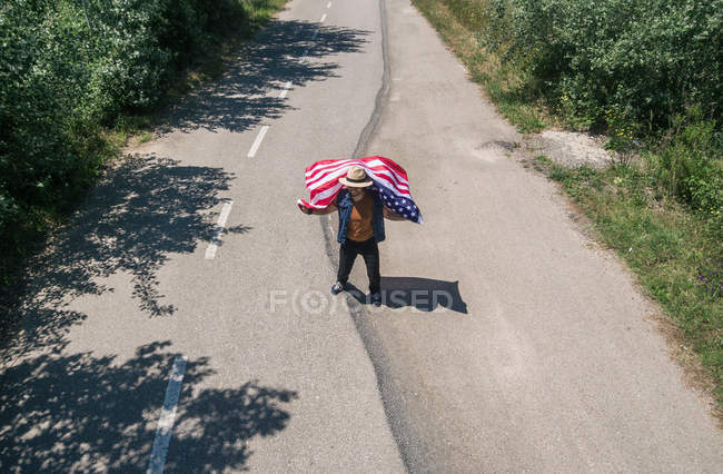 Man in hat showing American flag — Stock Photo