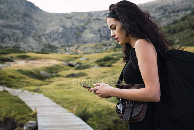 Junge hübsche Frau nutzt Smartphone in der Natur — Stockfoto