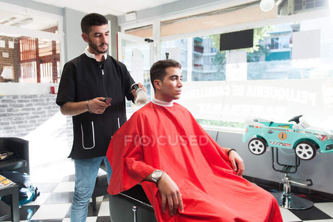 Hombre marroquí trabajando en su peluquería - foto de stock