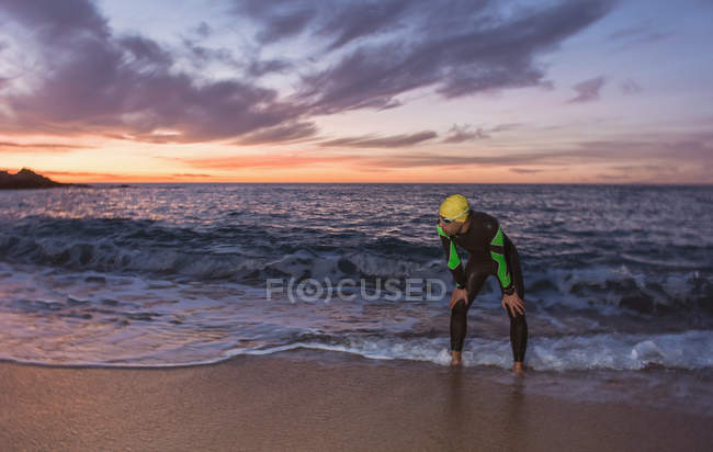 Triathlete standing at sea — Stock Photo
