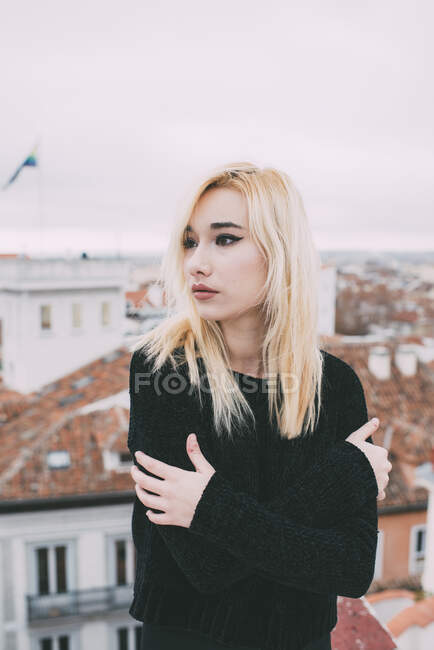 Jeune femme blonde debout sur le toit — Photo de stock