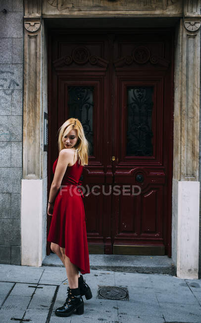 Jeune femme attrayante debout devant la vieille porte — Photo de stock