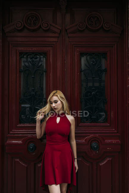 Jeune femme attrayante debout devant la vieille porte — Photo de stock