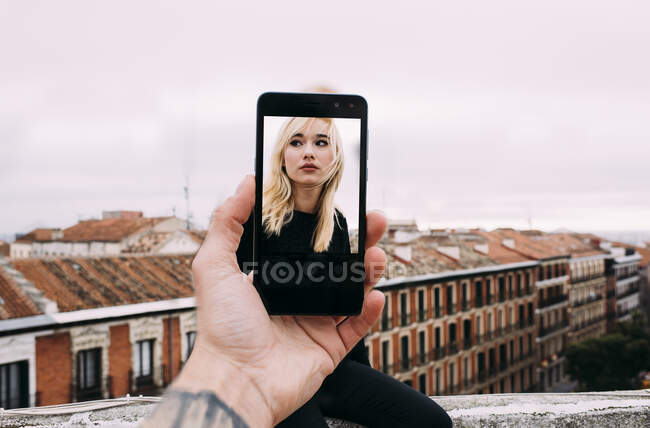 Portrait of young blonde girl trough telephone — Stock Photo
