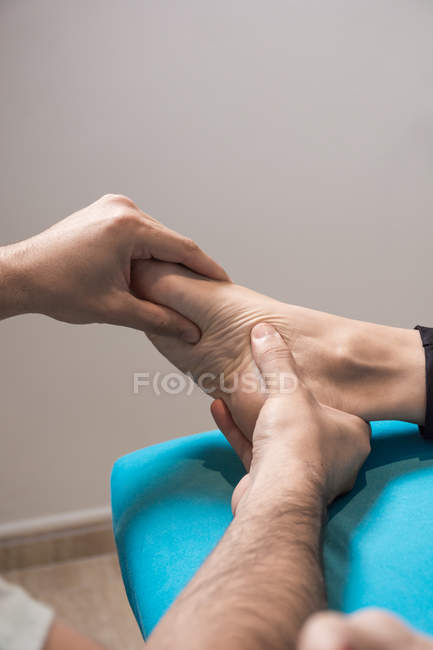 Therapist massaging female foot in massage room — Stock Photo