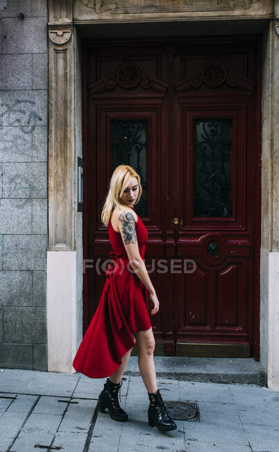 Giovane donna attraente in piedi di fronte al vecchio cancello — Foto stock
