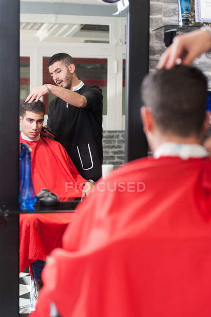 Hombre marroquí trabajando en su peluquería - foto de stock