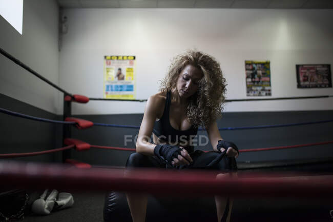 Fitness donna in abiti sportivi avvolgimento benda da boxe — Foto stock
